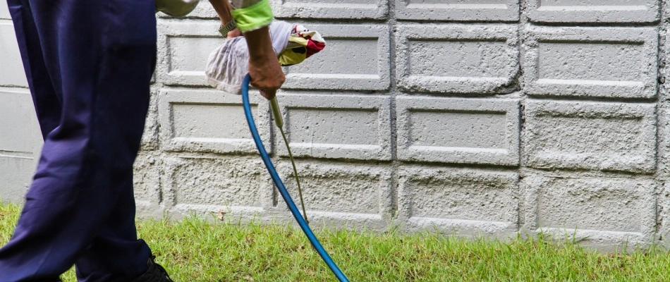 Professional spraying perimeter pest control treatment to foundation of home in Carmel, IN.