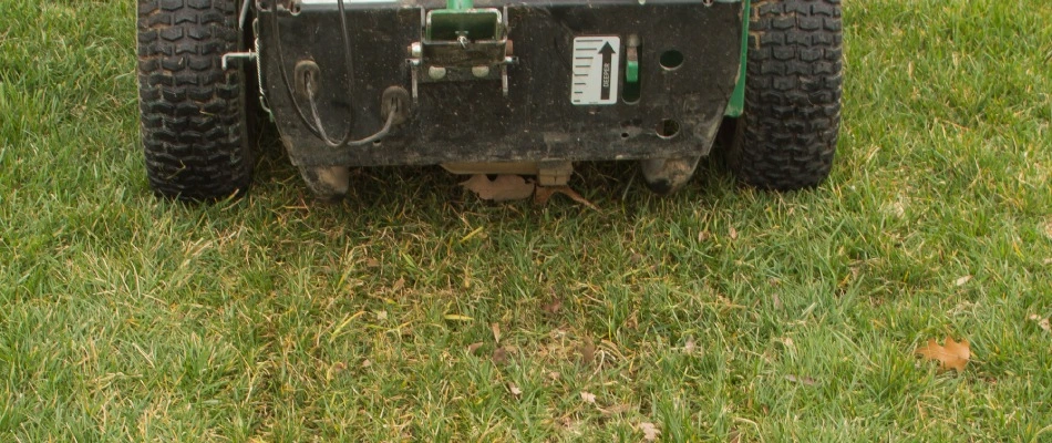 Slit seeding machine in lawn creating lines in lawn in Fishers, IN.